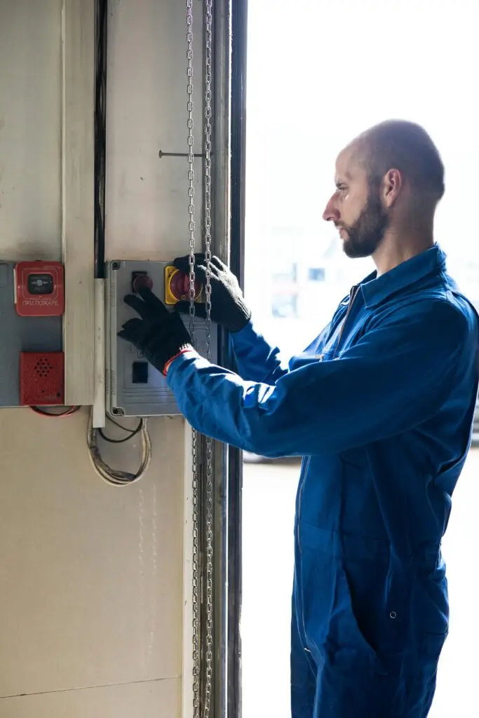 pexels-photo-8986042-8986042 A technician in blue overalls operates a control switch inside a facility, focused and attentive.